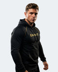 A muscular man wearing a black long-sleeve athletic hoodie with gold 'EARN IT' text on the chest, posed against a light gray background.